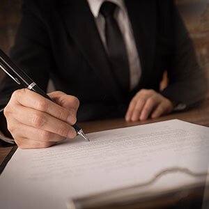 A lawyer signs a document, symbolizing the legal process from arraignment to sentencing