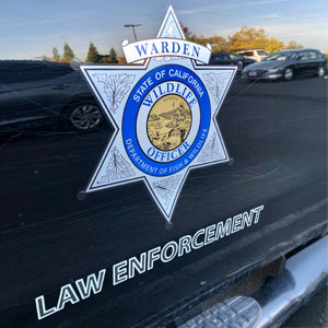 California Department of Fish and Wildlife Warden badge displayed on a law enforcement vehicle